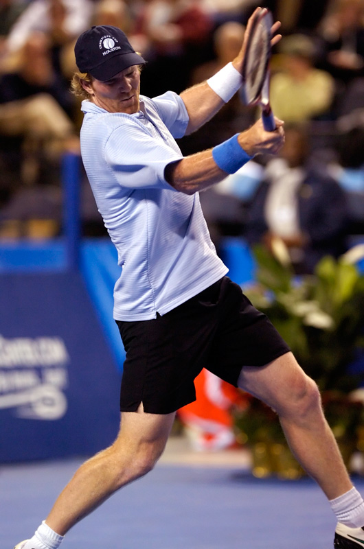 Jim Courier returns a serve from John McEnroe during their exhibition 